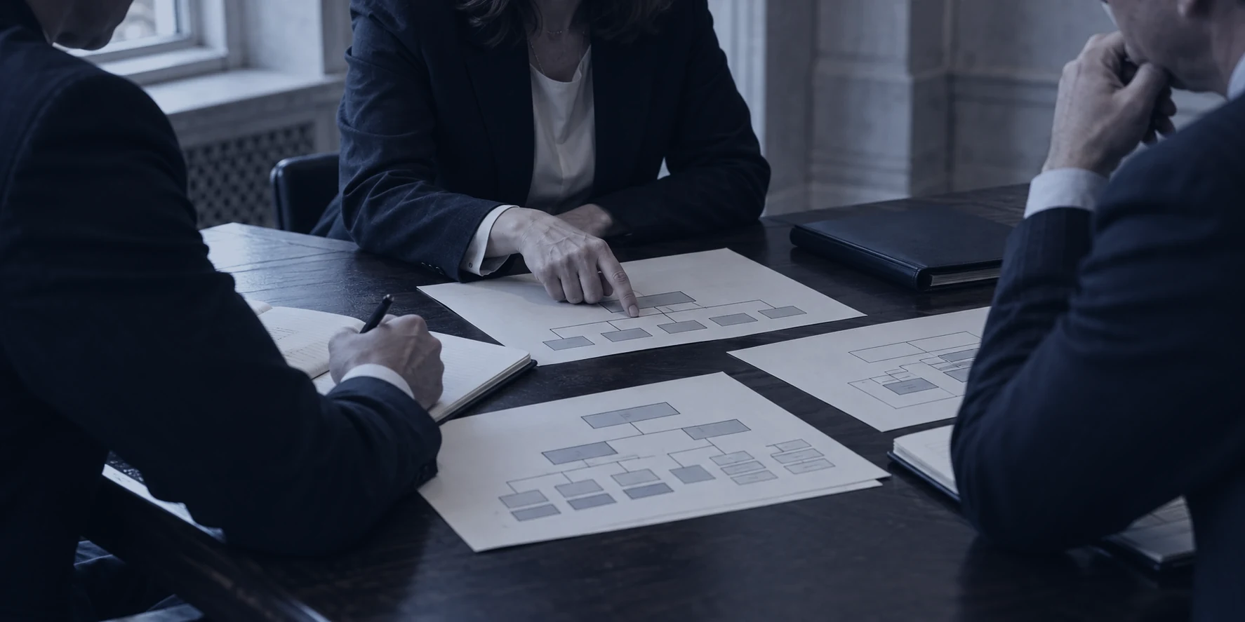 Illustration: specialists at a table discussing paper organisational charts